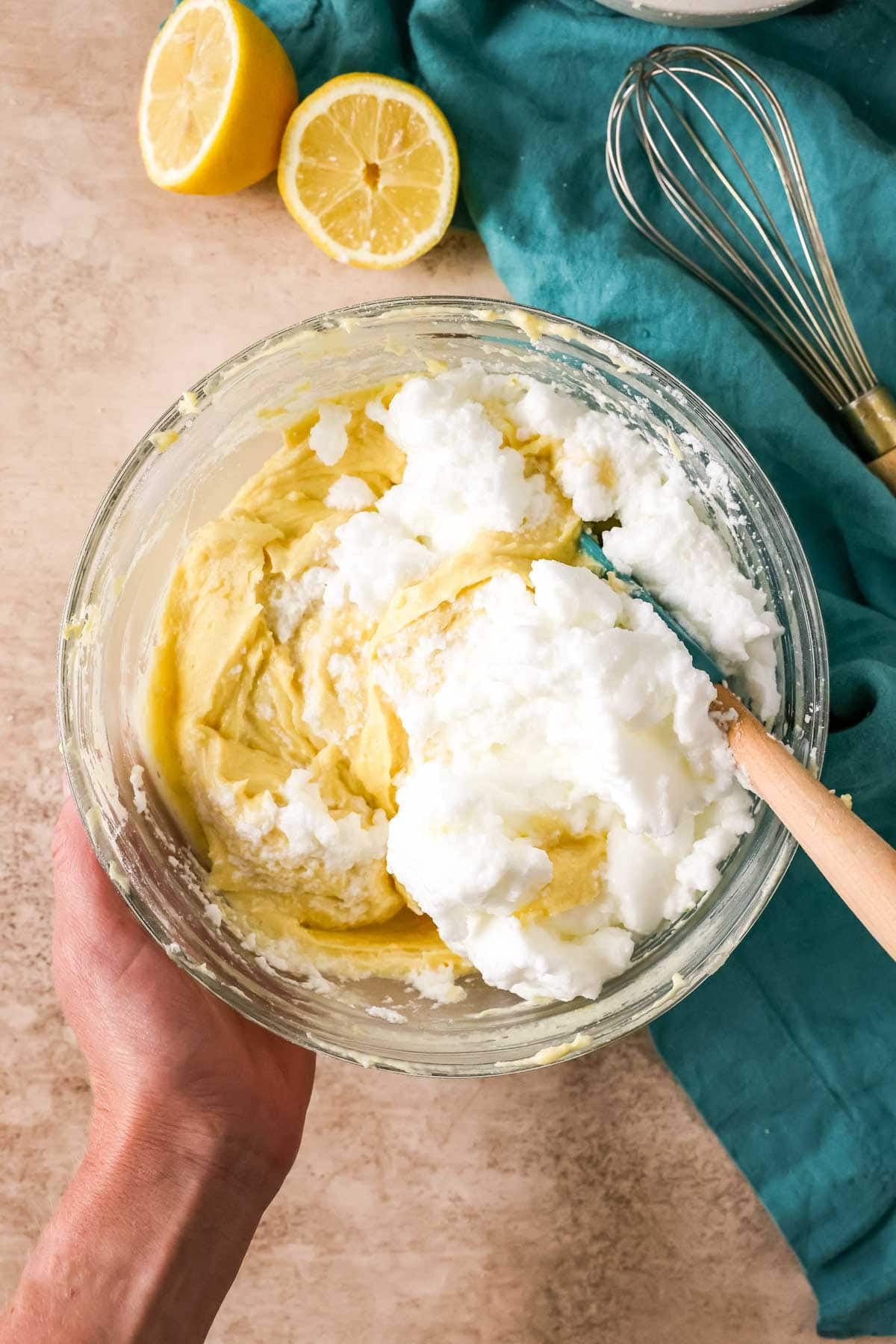 Folding whipped egg whites into a lemon loaf batter.