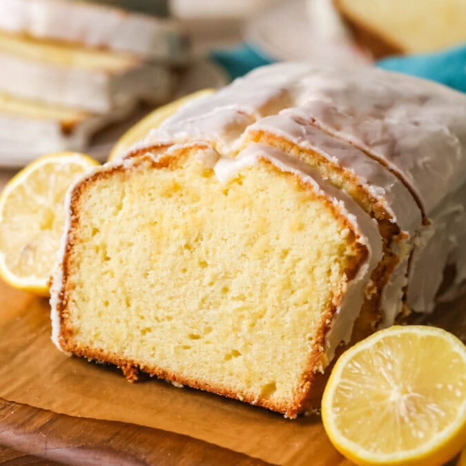 Lemon loaf with a few slices that have been cut and leaned against the loaf.