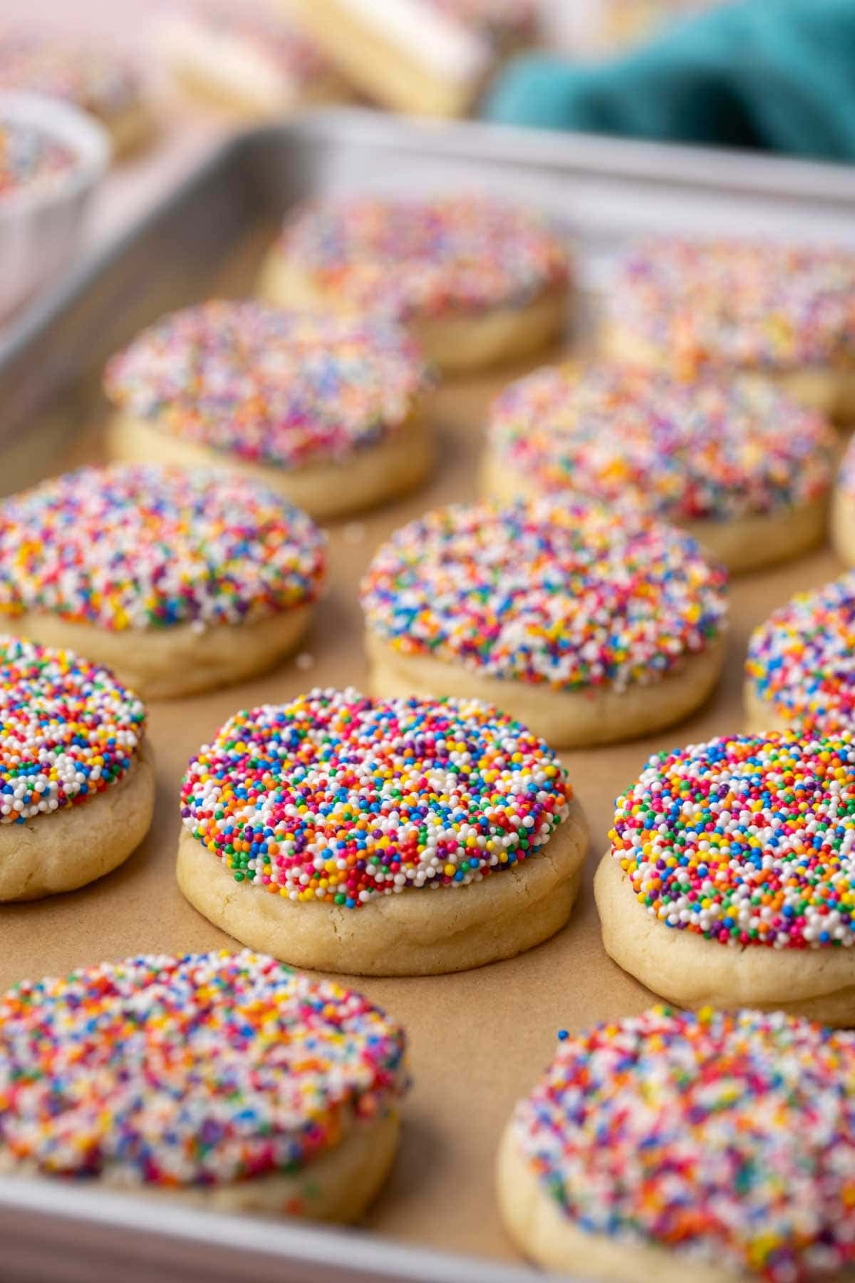Close-up of dot cake cookies in a parchment lined baking sheet.