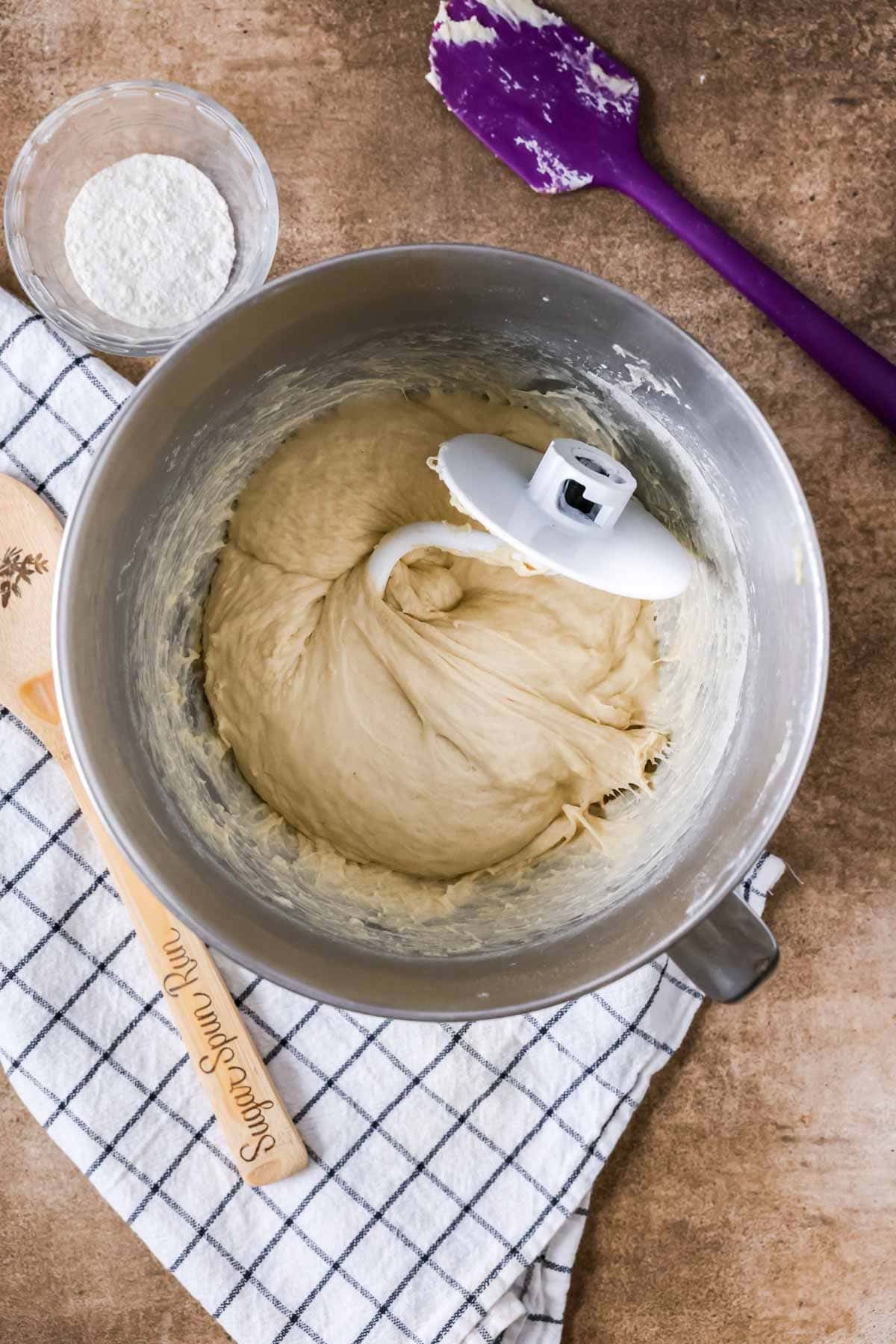 Overhead view of a dough in a mixer bowl after kneading with a dough hook.