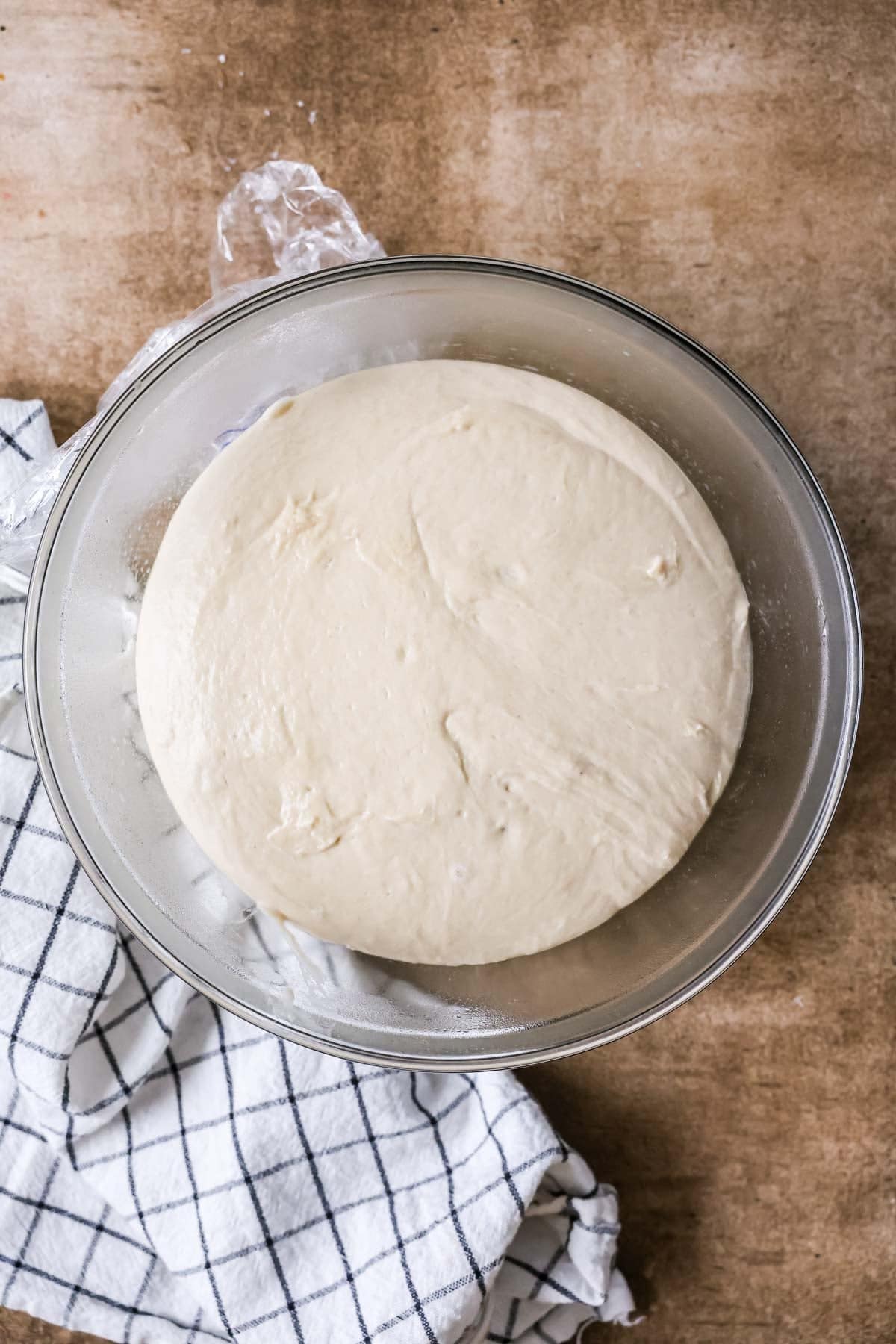Overhead view of a dough in a bowl after rising.