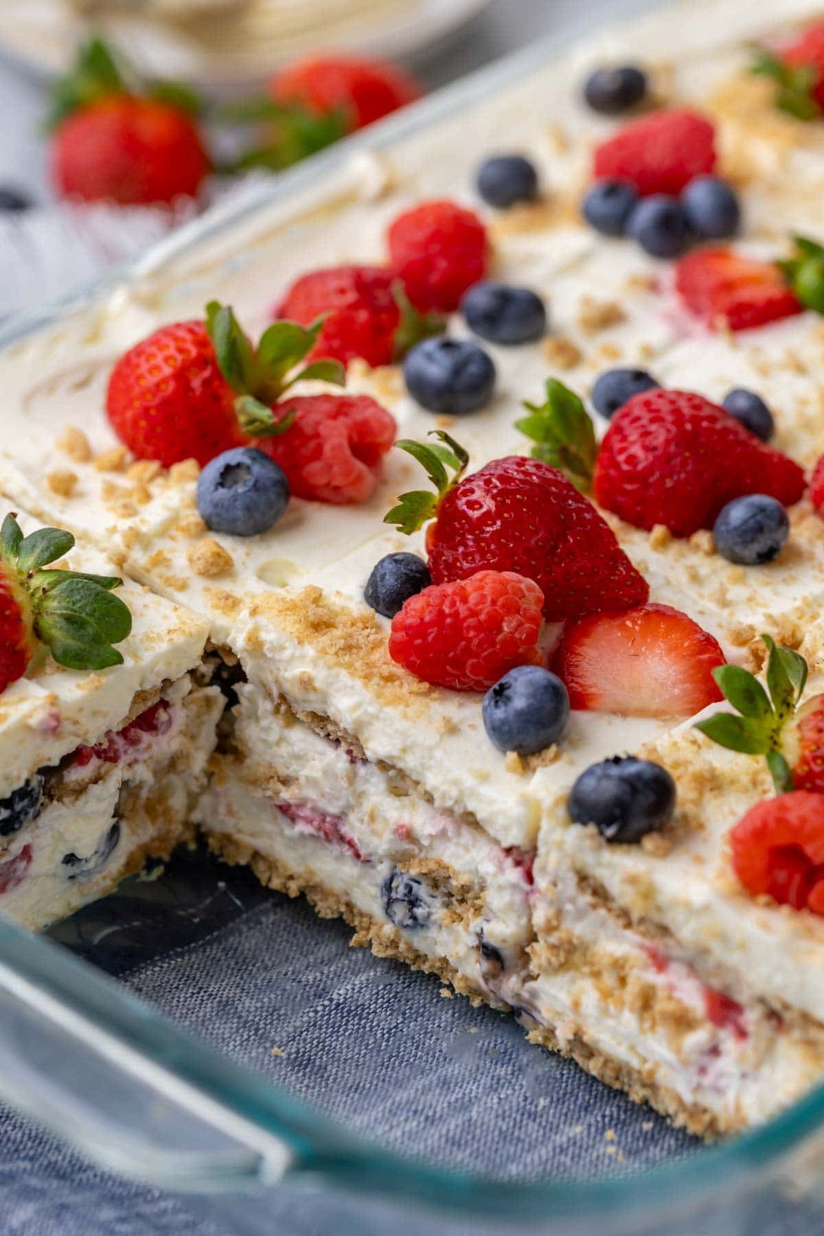 Square slices of berry icebox cake in a glass baking dish.