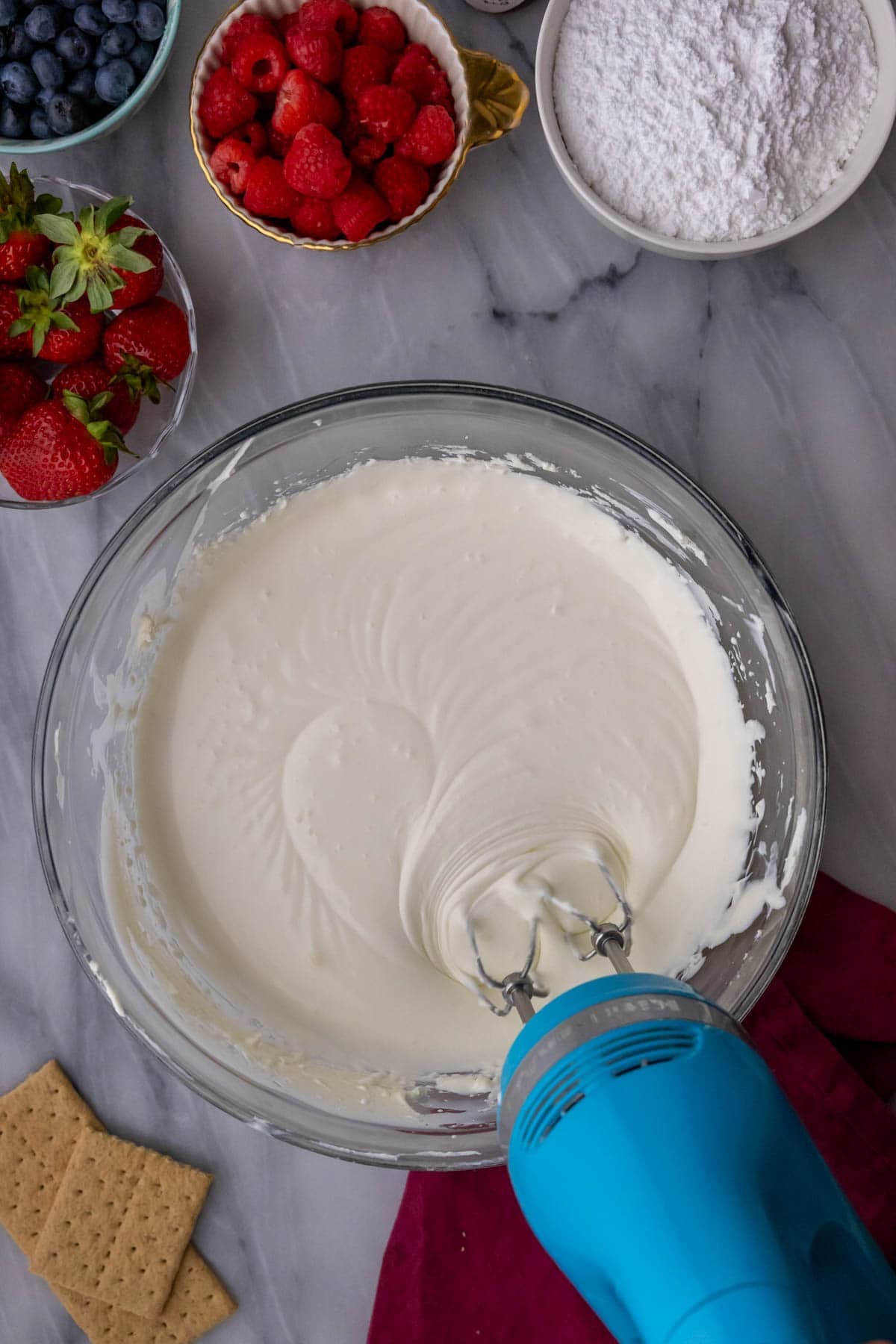 Beating heavy cream into cream cheese.