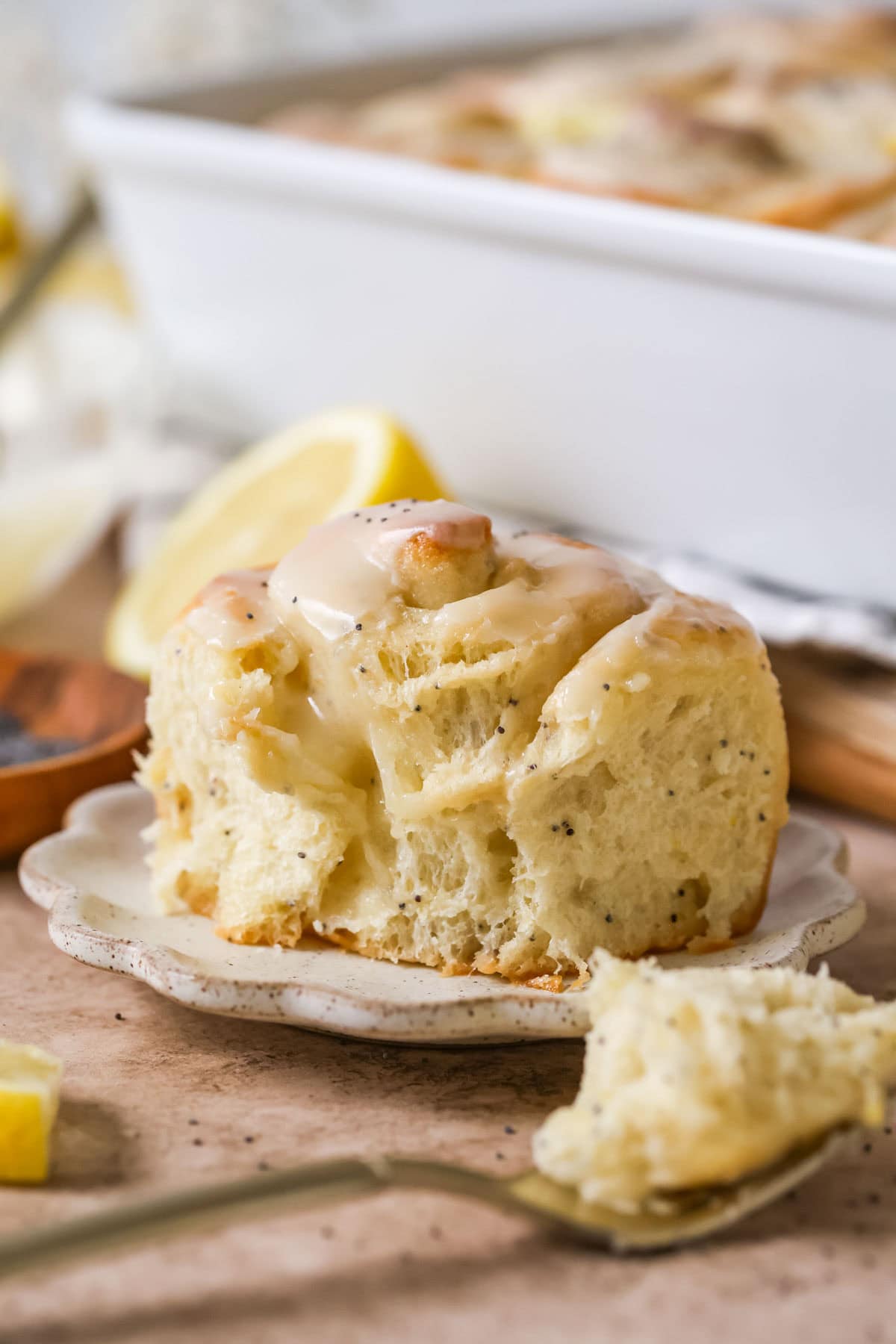 A lemon poppy seed sweet roll on a plate.