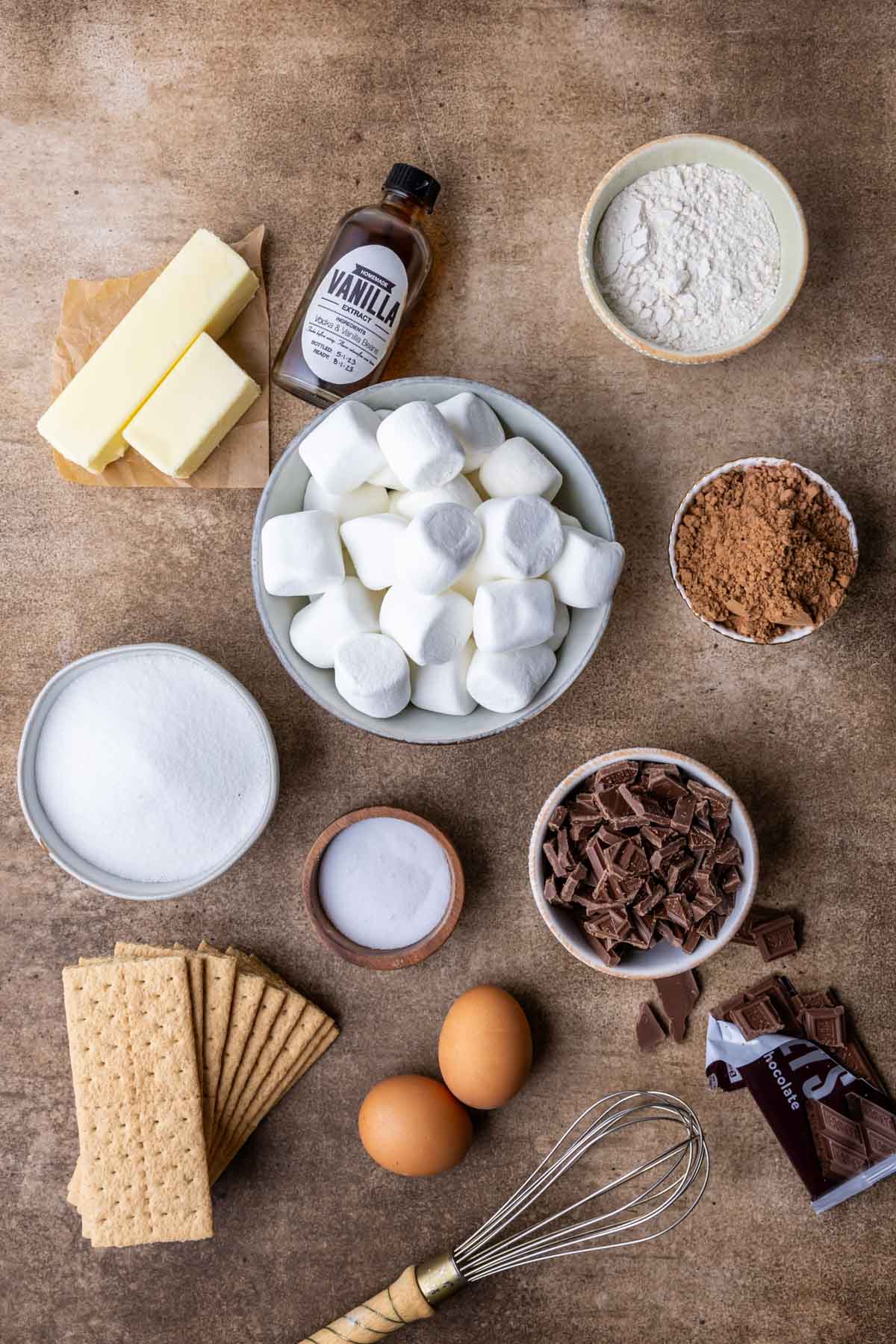Overhead view of ingredients including marshmallows, graham crackers, chocolate bars, and more.
