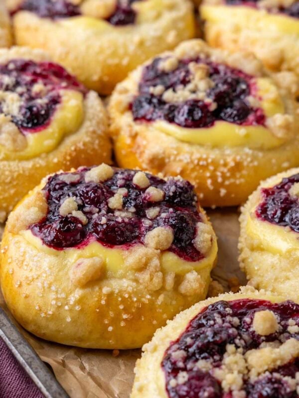 Close-up view of blueberry cheesecake buns topped with streusel and coarse sugar.