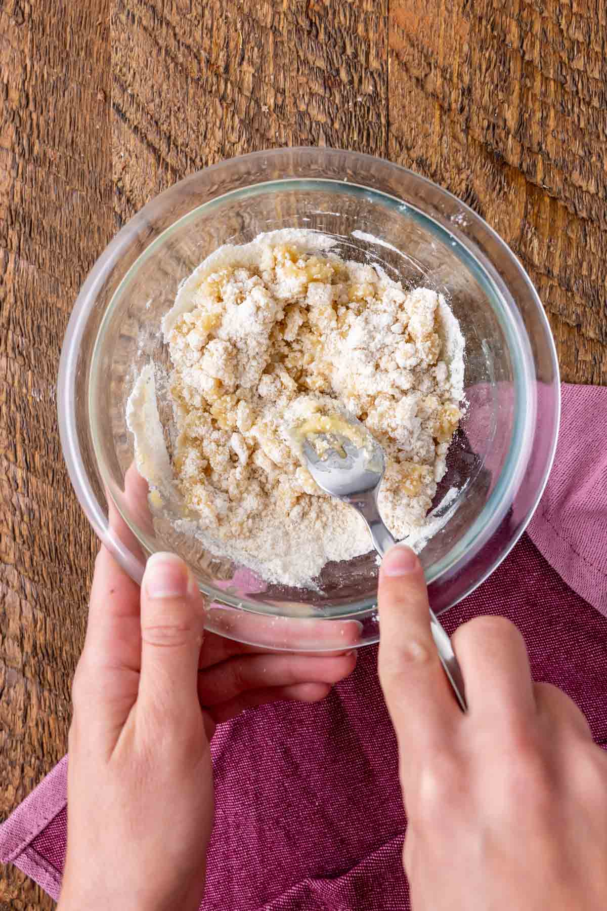 Overhead view of a bowl of streusel being clawed together.