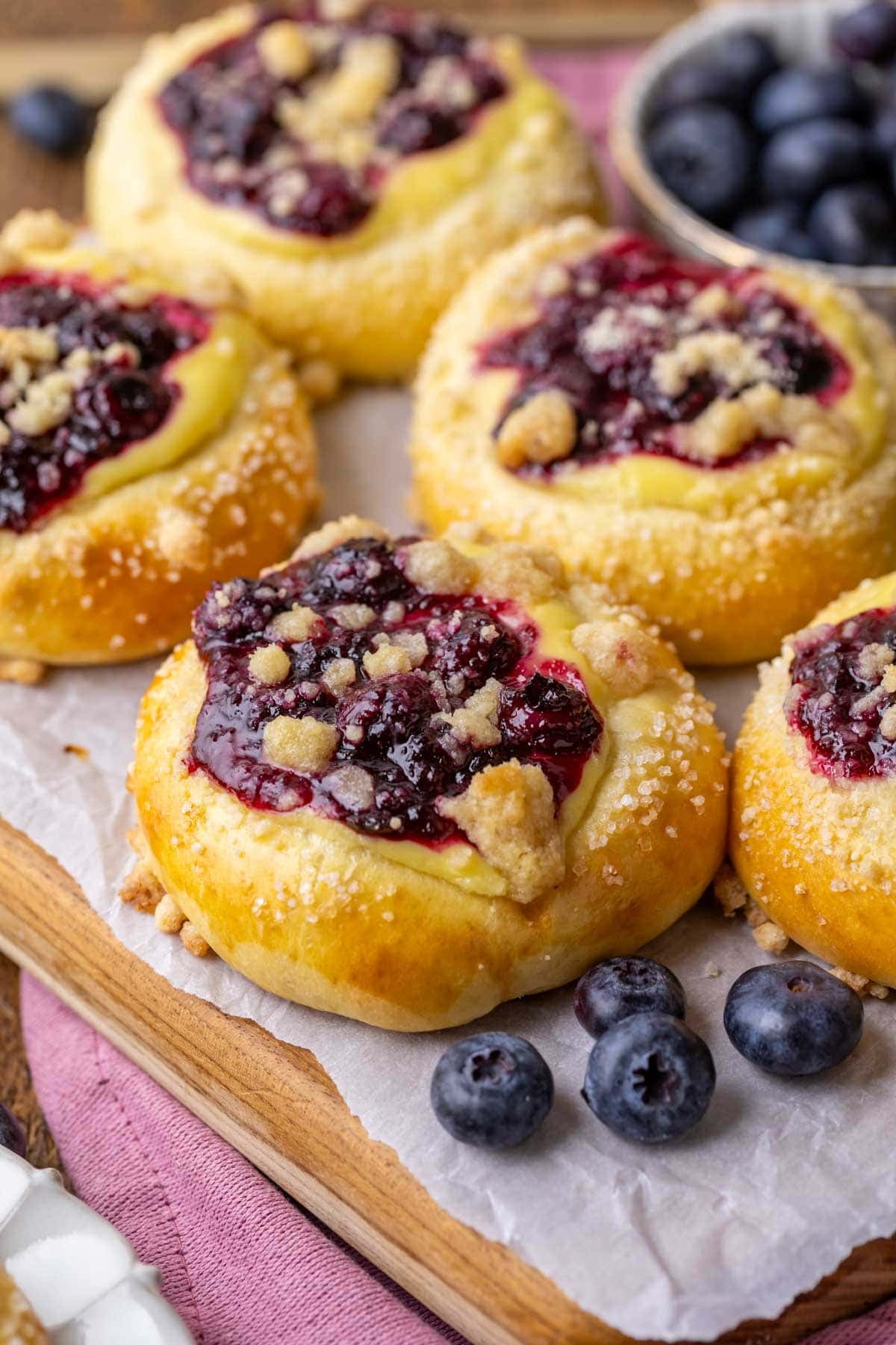 Blueberry cream cheese buns topped with streusel and coarse sugar.