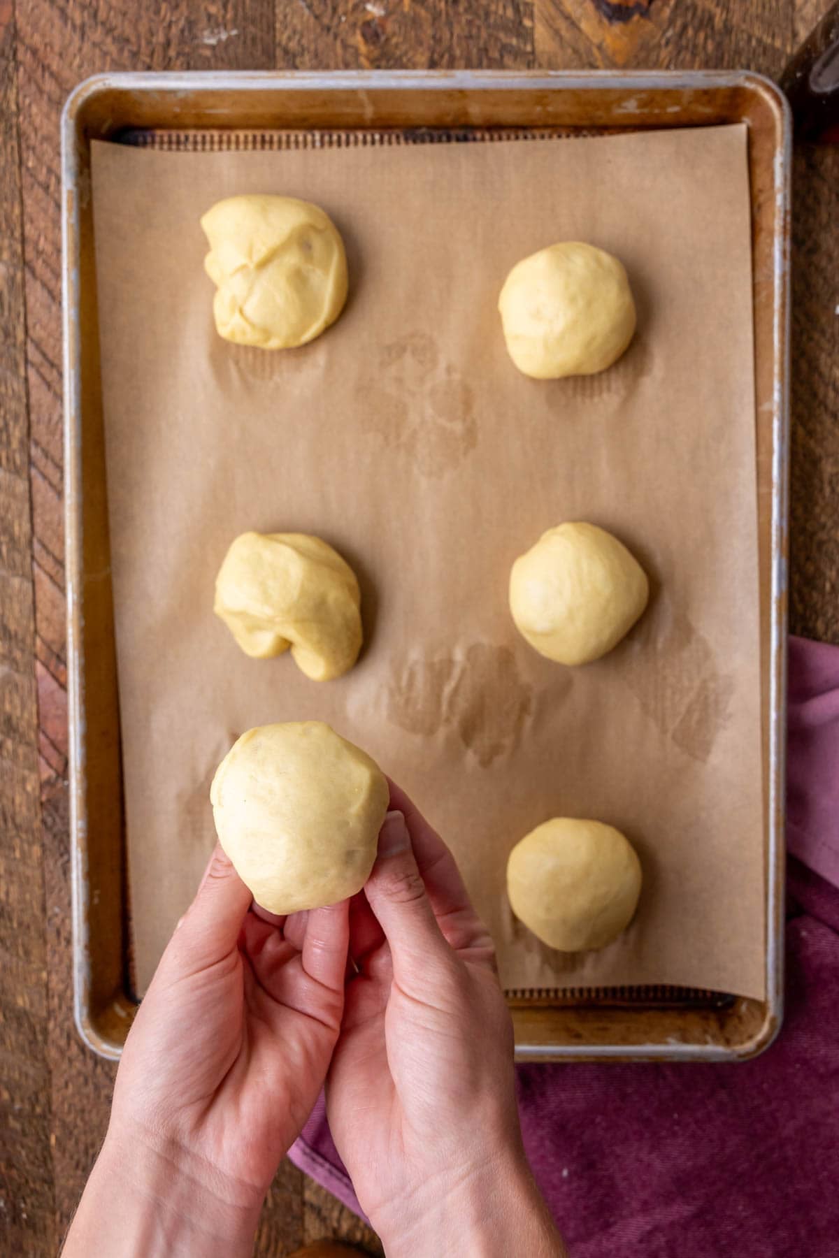 Forming dough into smooth, round balls.