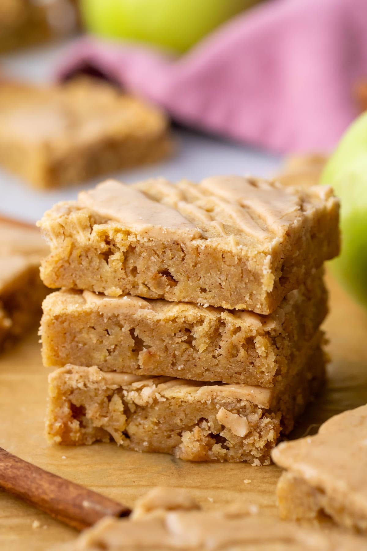 Stack of three blondies with diced apples throughout and a maple glaze on top.