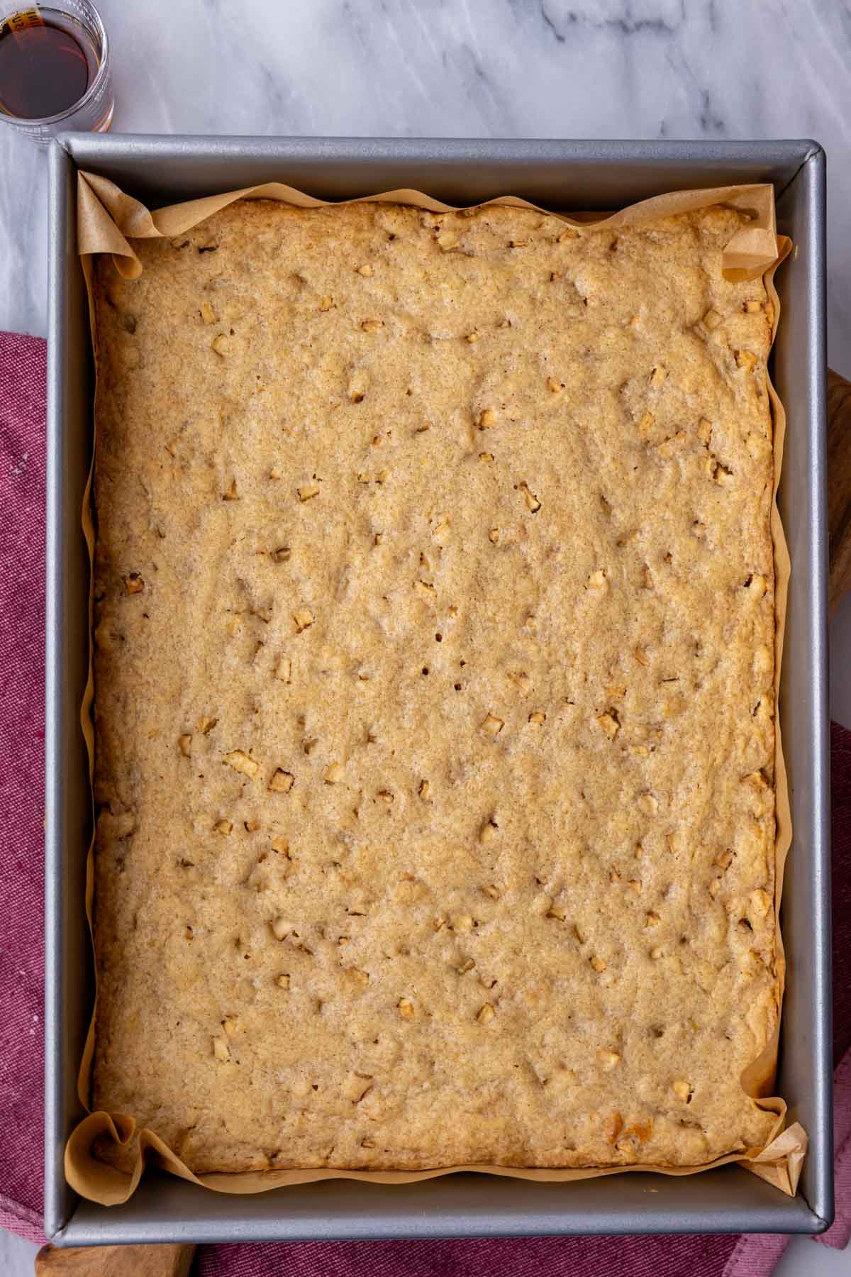 Overhead view of a pan of apple blondies before cutting and frosting.