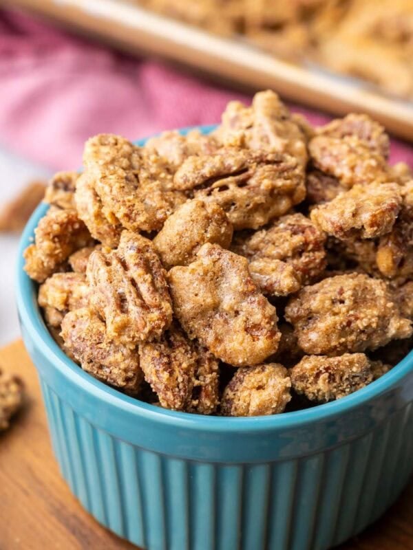 Close-up view of a blue ramekin filled with candied pecans.