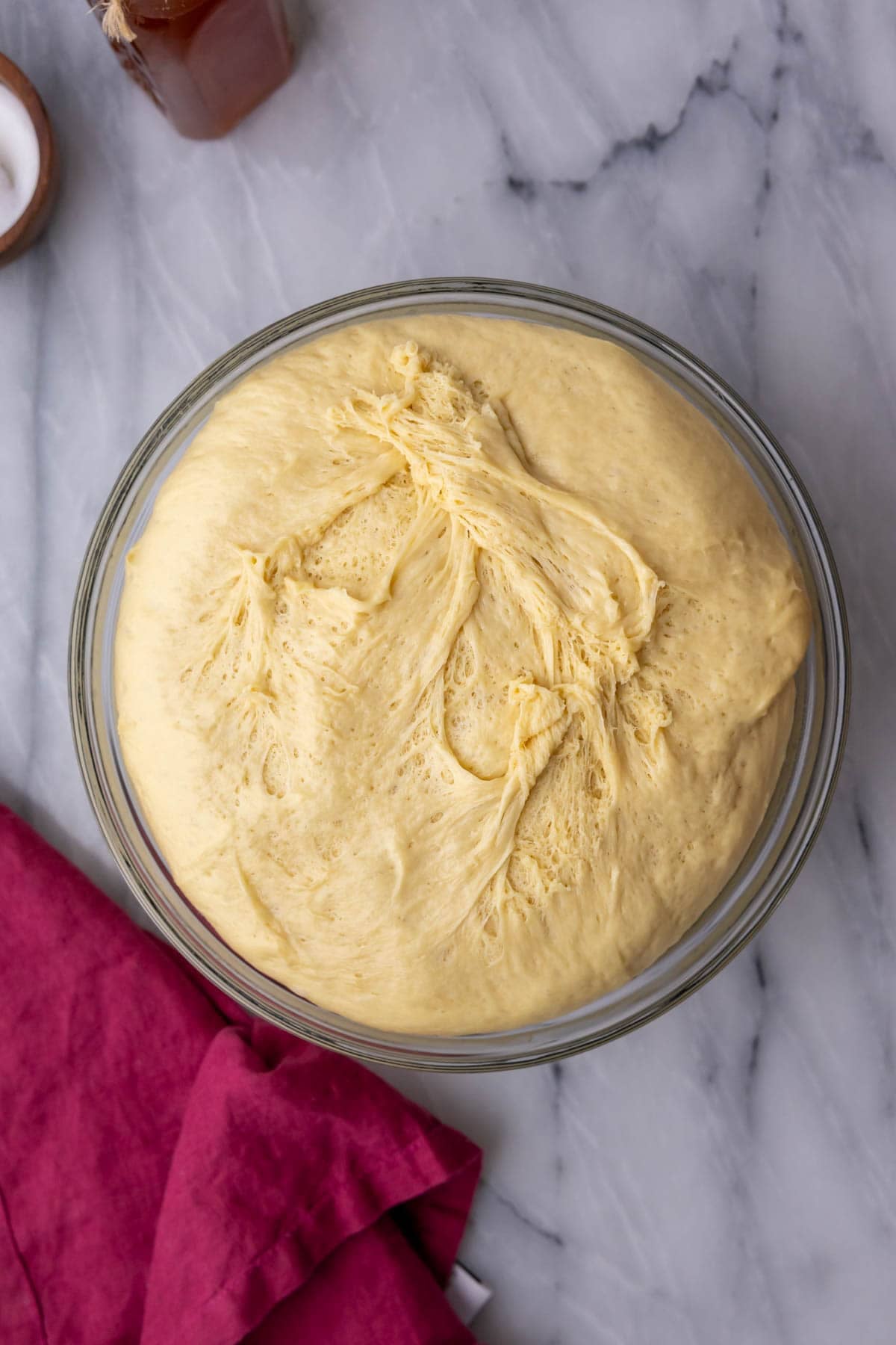 Overhead view of risen dough in a glass bowl.