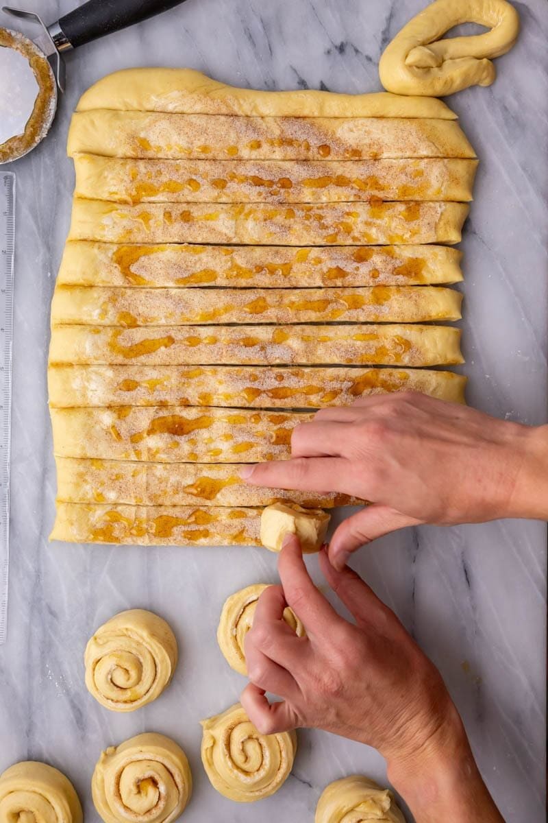 Rolling honey buns into swirl shapes.