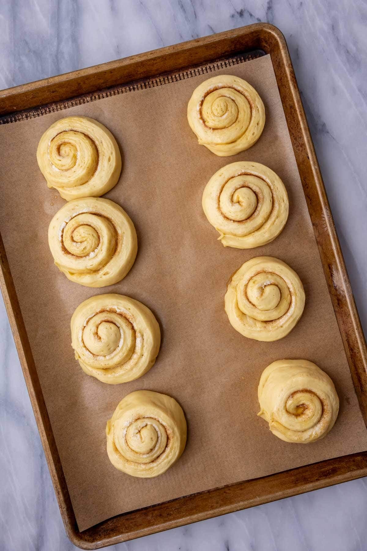 Overhead view of swirled honey buns after rising.