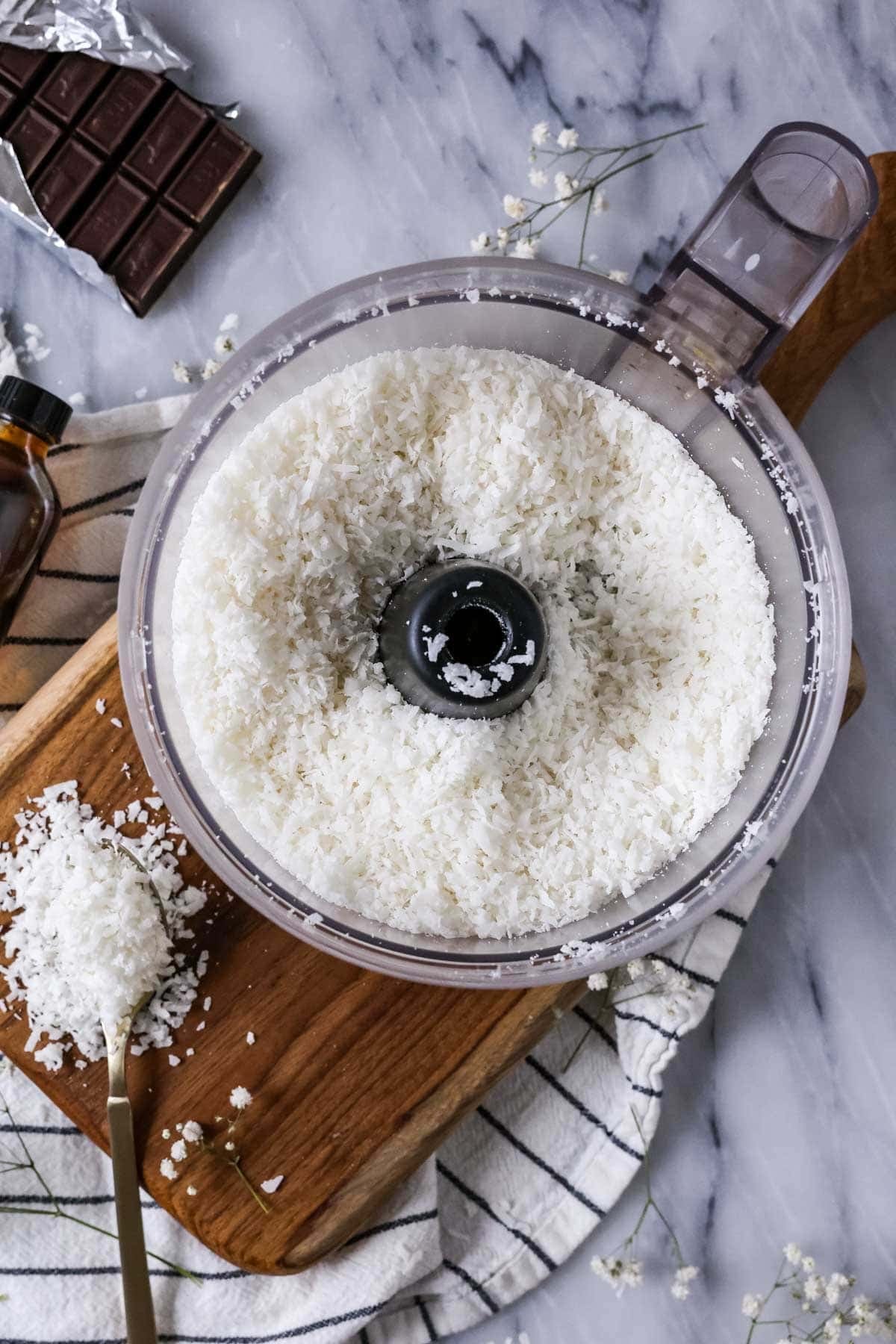 Overhead view of coconut in a food processor after pulsing.