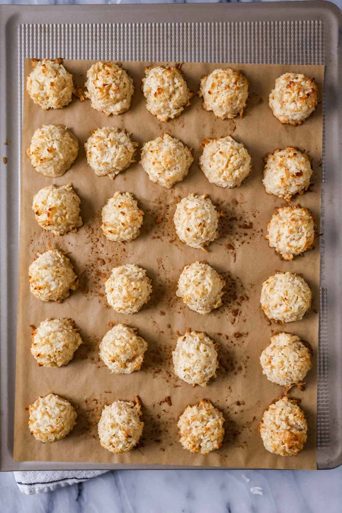 Overhead view of coconut macaroons on a baking sheet after baking.