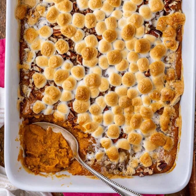 Overhead view of sweet potato casserole in a white dish with a spoon in the dish.