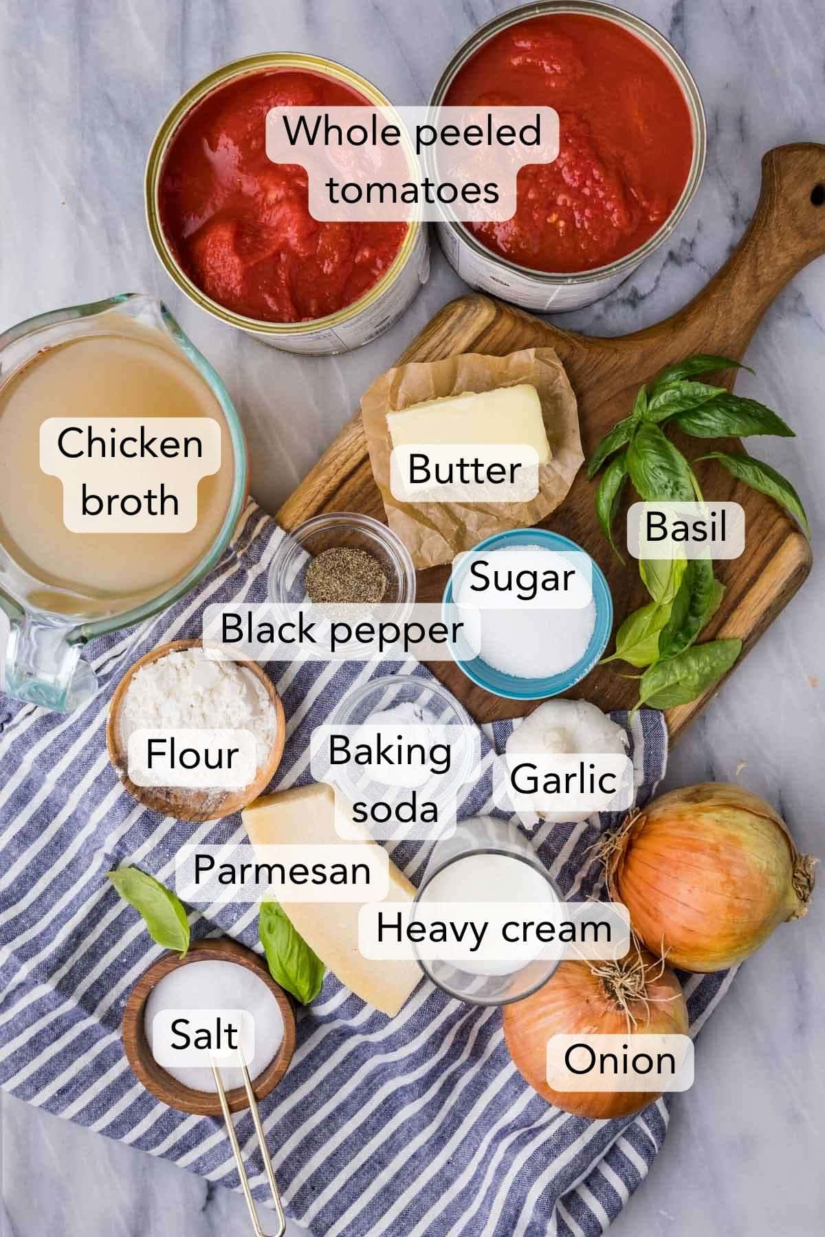 Overhead of the (labeled) ingredients for my tomato soup recipe on marble.