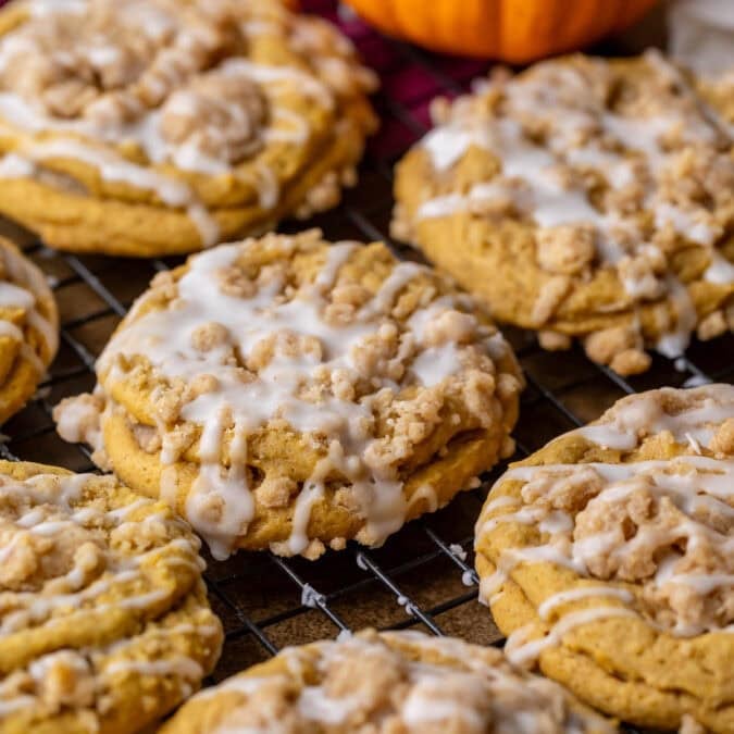 Overhead view of pumpkin coffee cake cookies topped with streusel and vanilla glaze.