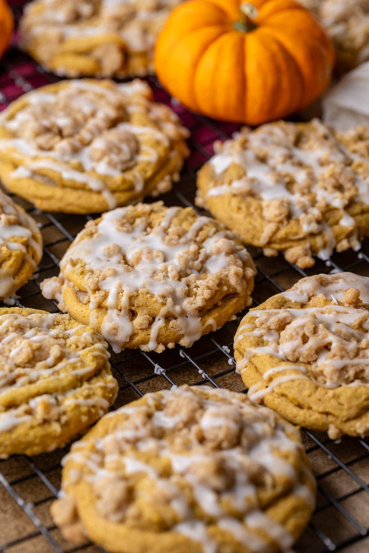 Overhead view of pumpkin coffee cake cookies topped with streusel and vanilla glaze.