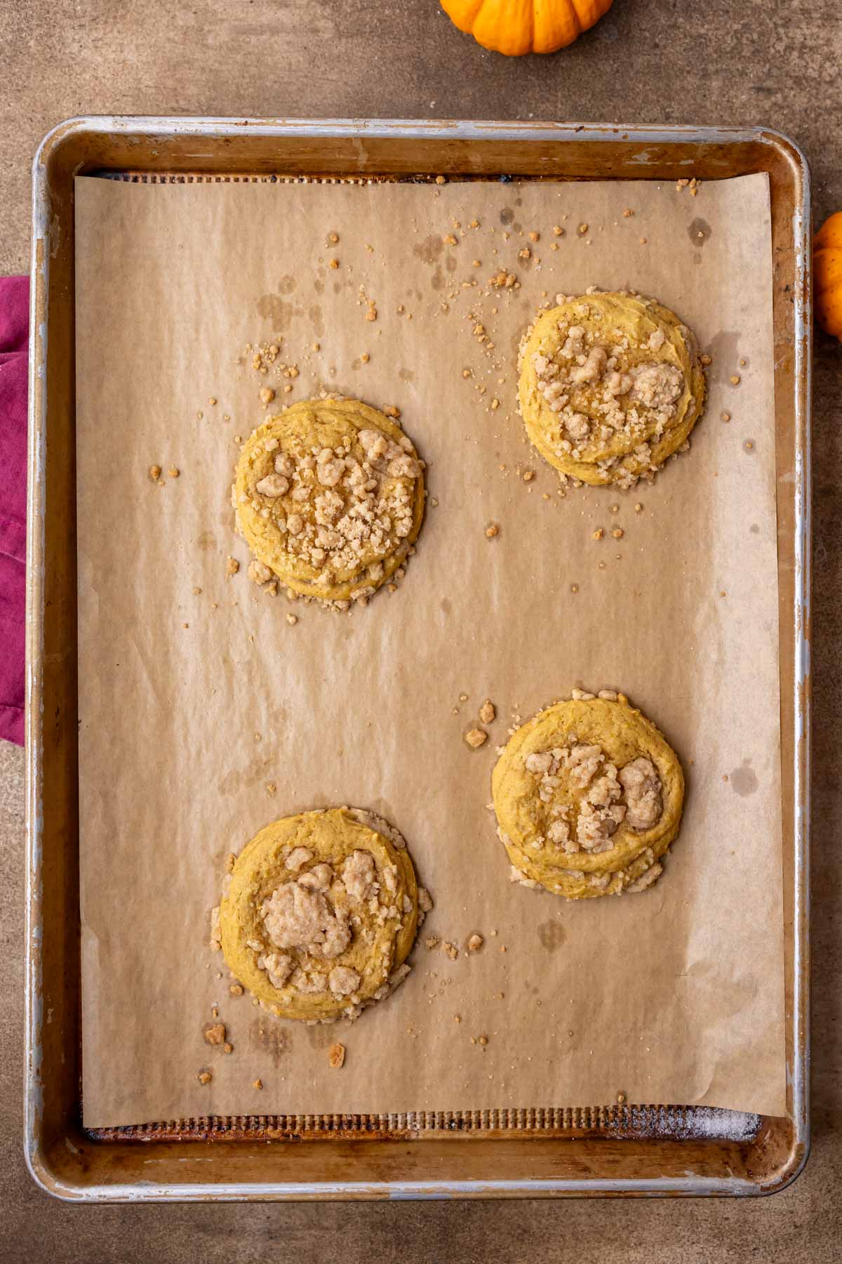 Overhead view of baked pumpkin coffee cake cookies on a baking sheet.
