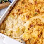 Close-up view of a pan of scalloped potatoes with a golden brown crust and creamy interior.