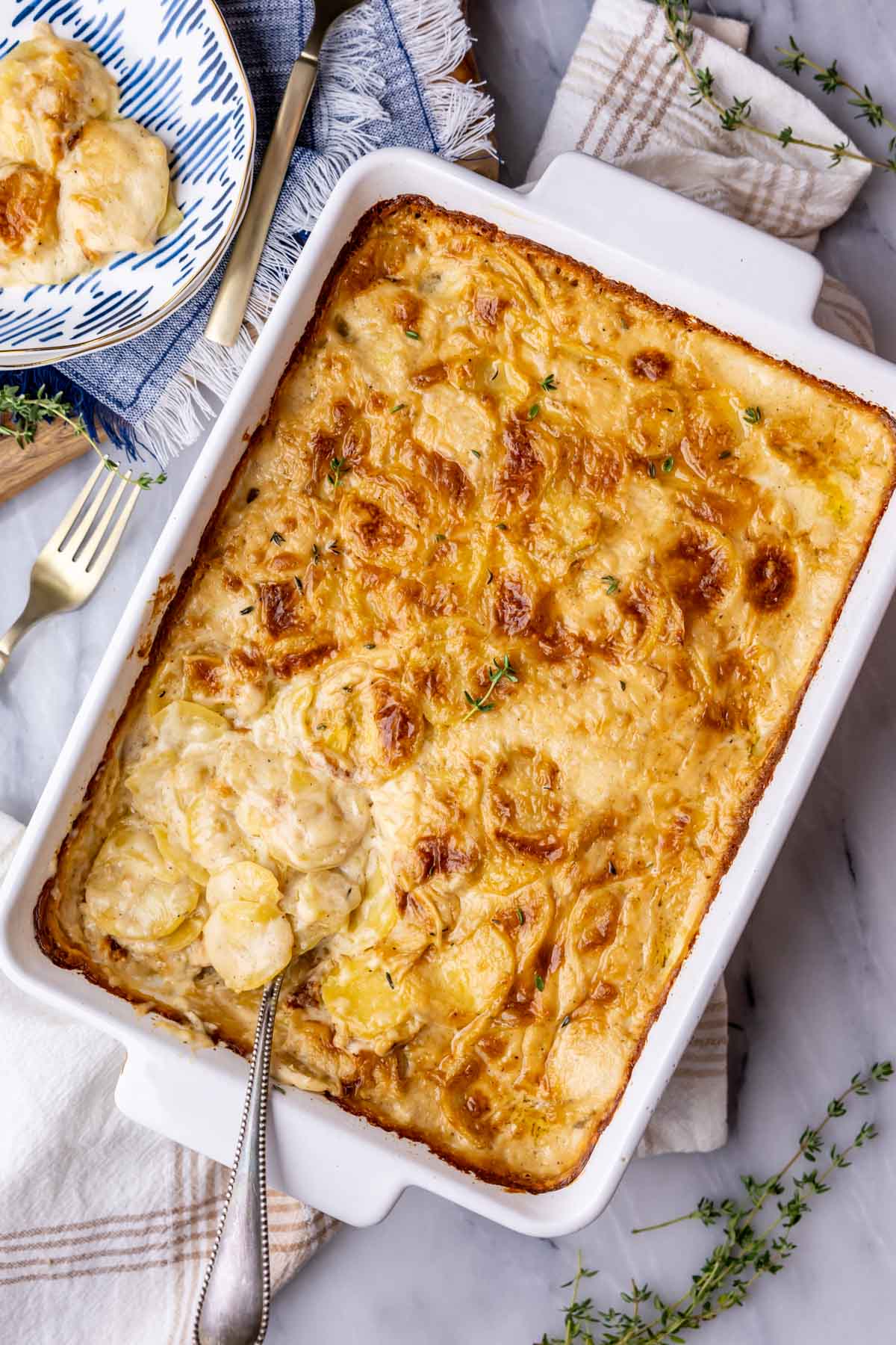 Overhead view of a pan of golden brown scalloped potatoes.