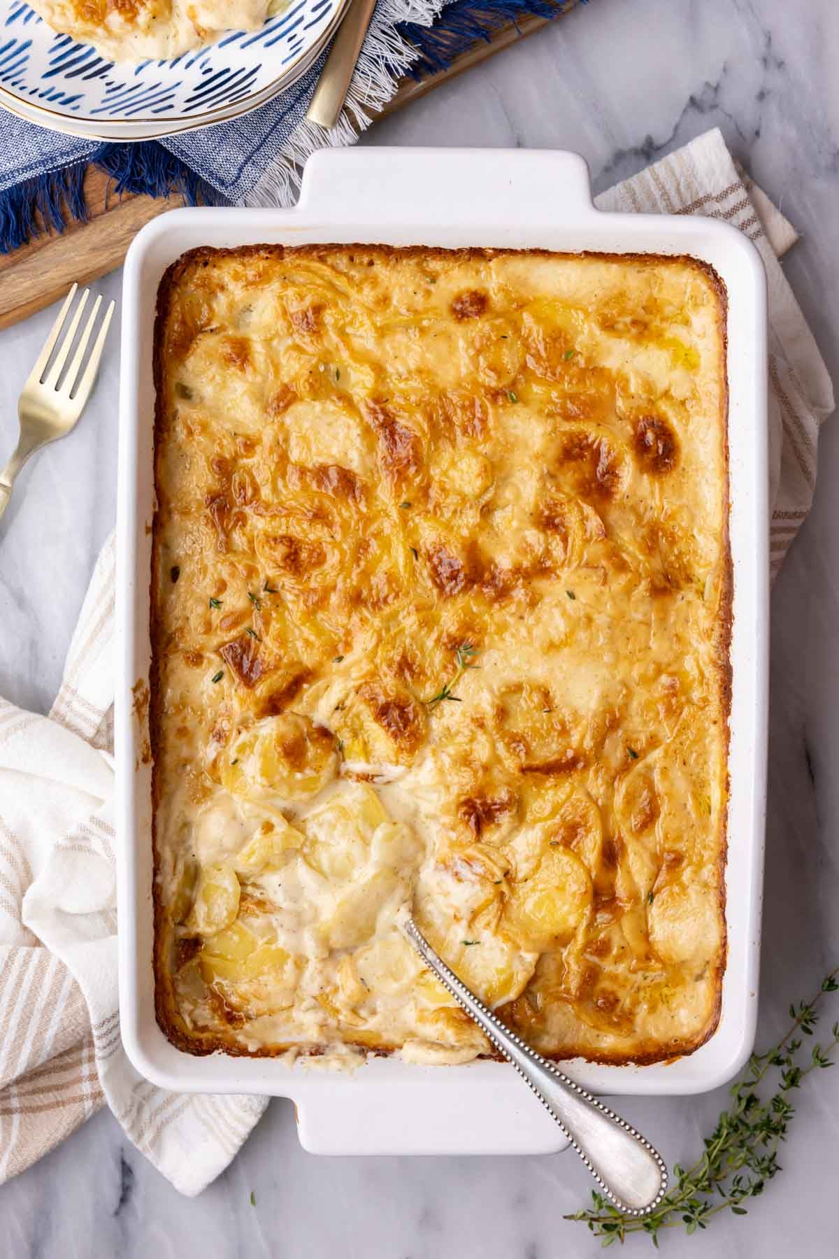 Overhead view of a pan of golden brown scalloped potatoes.