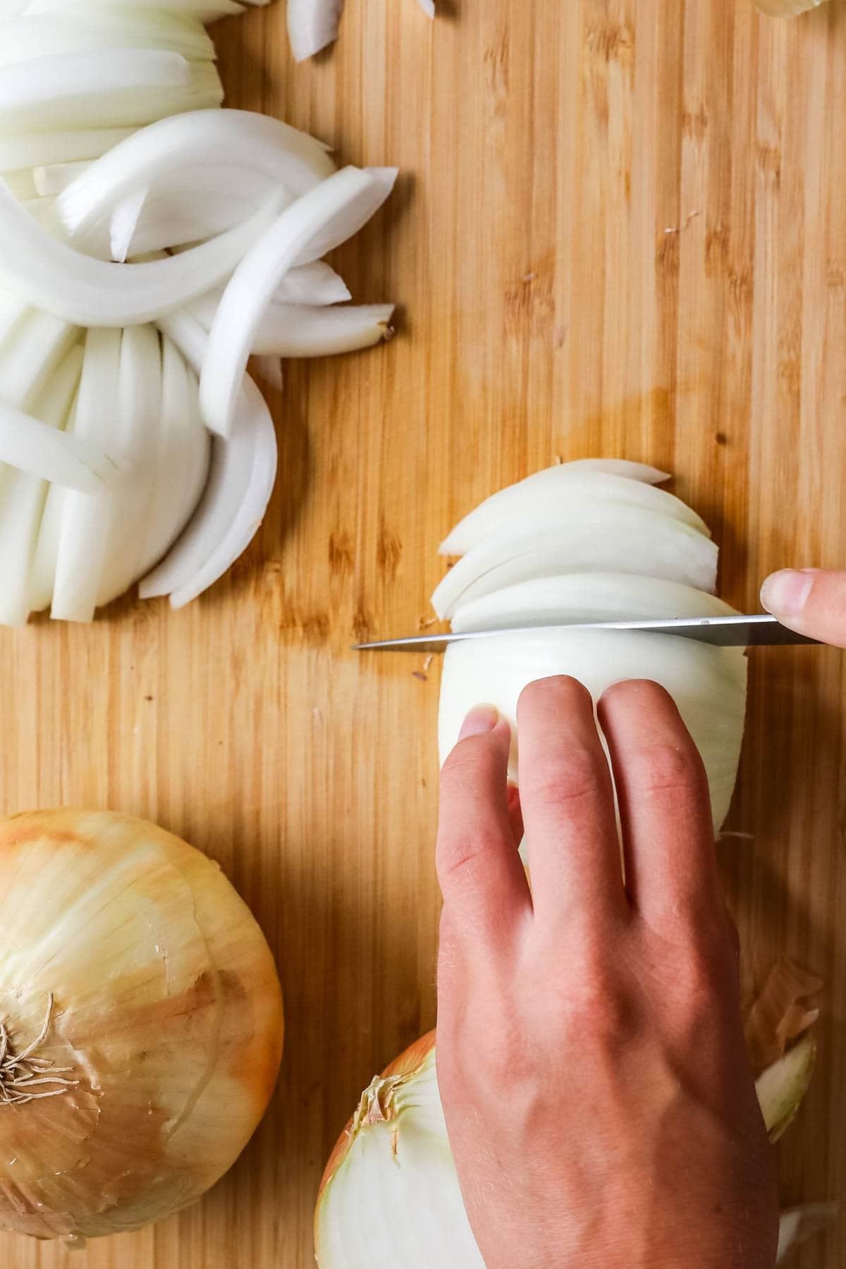 Slicing onions into strips for caramelizing.