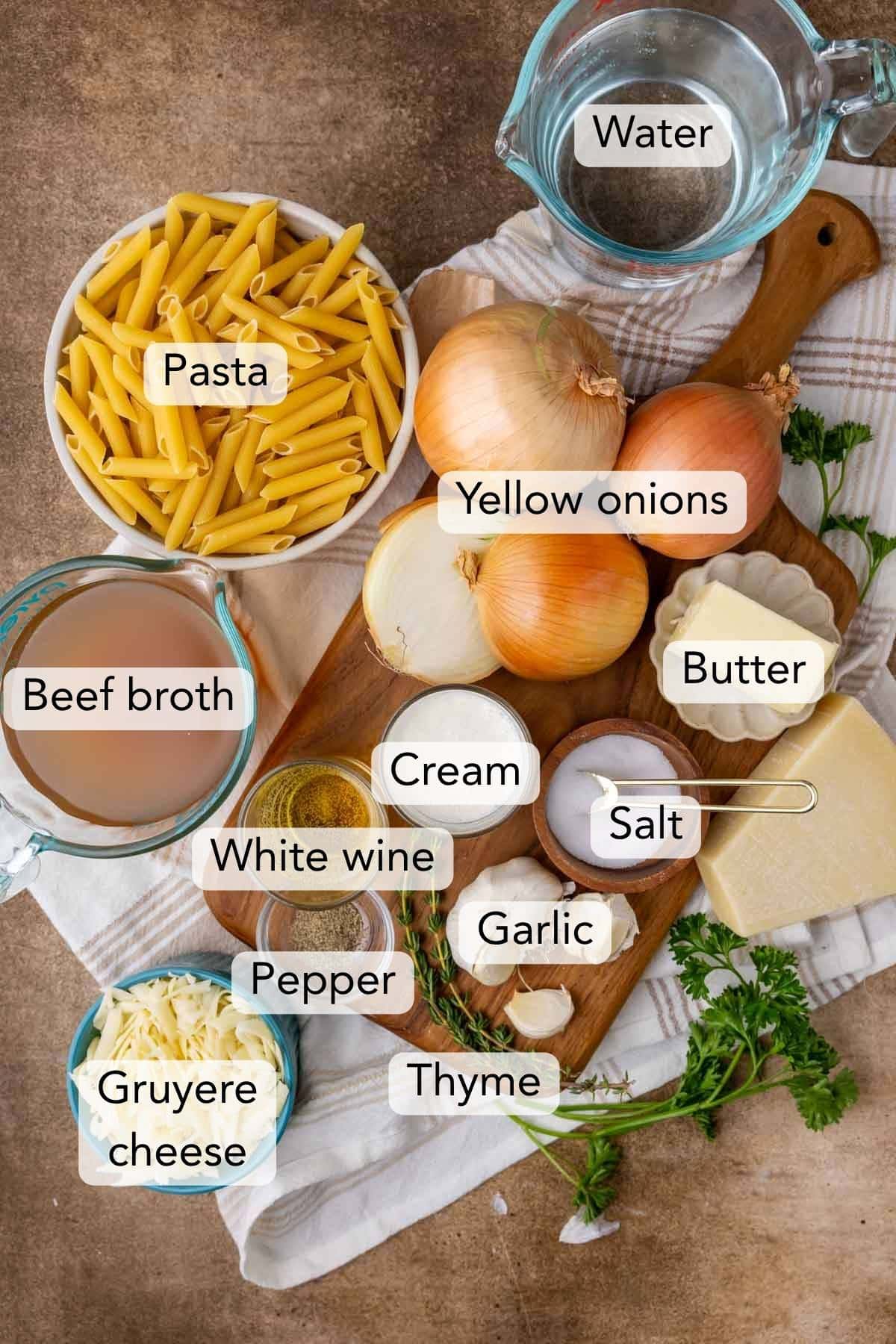 Overhead view of ingredients including onions, pasta, beef broth, and more.