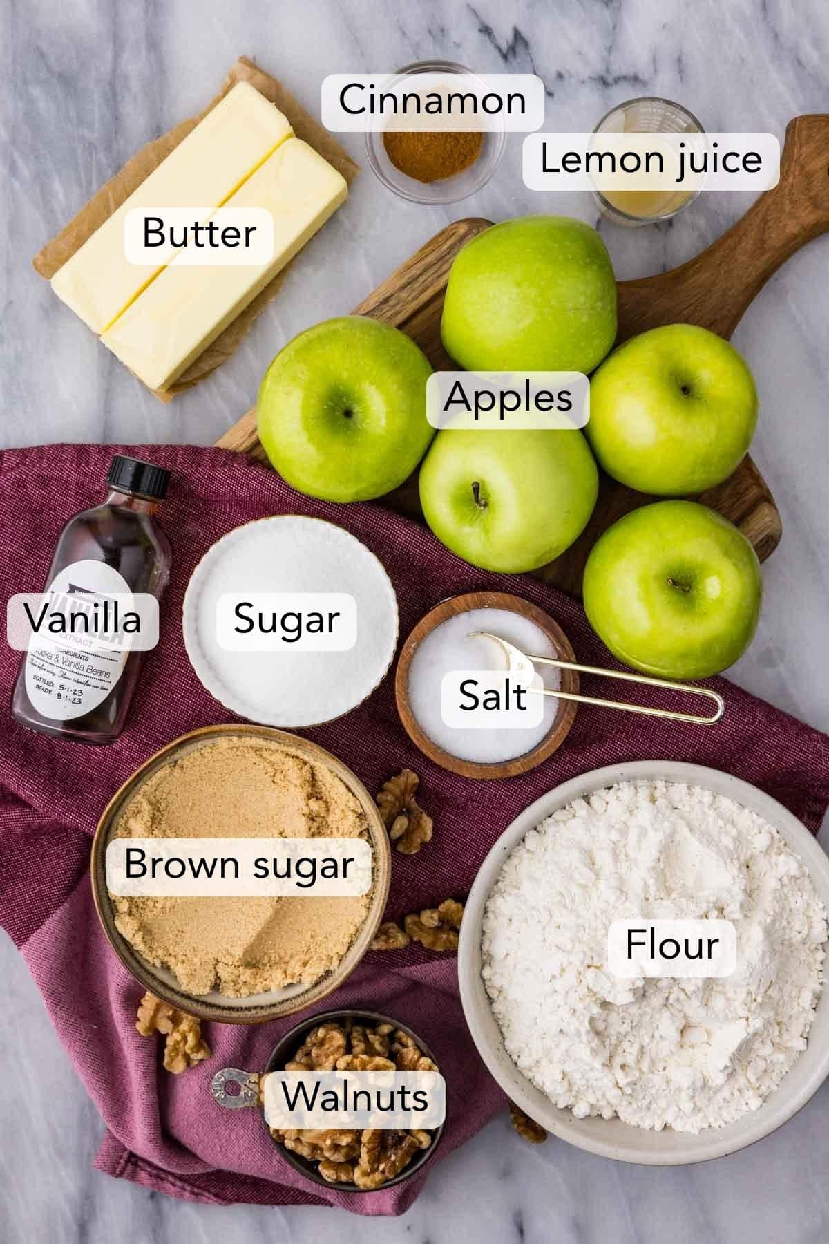 Overhead view of ingredients including apples, walnuts, brown sugar, and more.